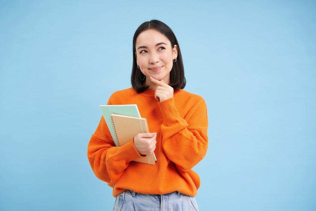 Student thinking about future with notebooks in her hand.